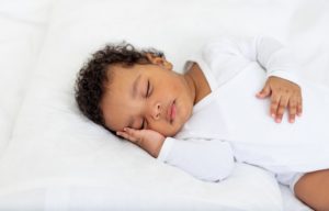 What Is the Best Room Temperature for a Sleeping Baby? A baby sleeps peacefully.