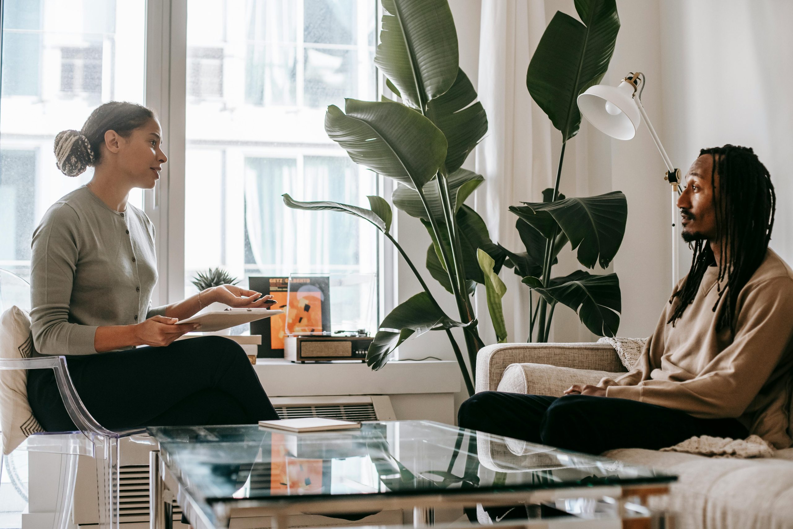 A thoughtful therapy session between a psychologist and a client in a modern office setting.