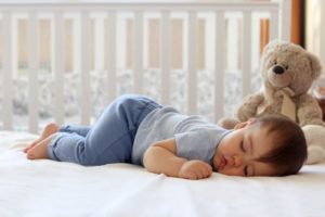 When Do Babies Sleep Through the Night A baby sleeping in a crib